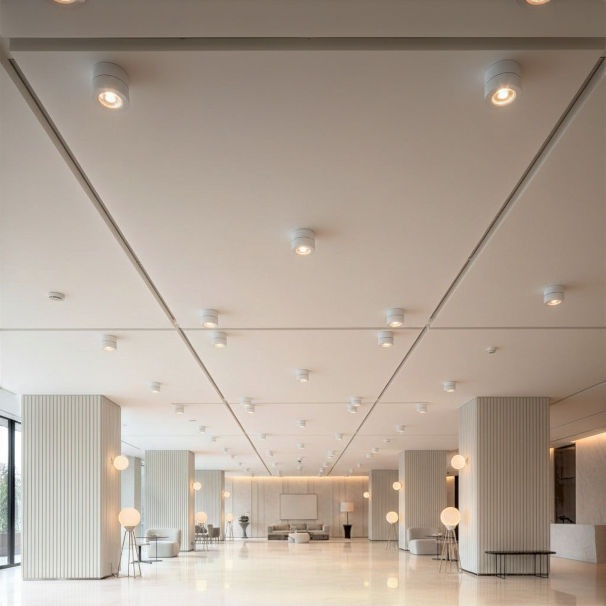 white adjustable ceiling light mounted on a high ceiling in a hotel