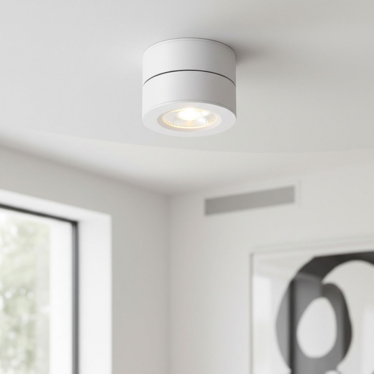 white adjustable ceiling light mounted on a white ceiling in a living room