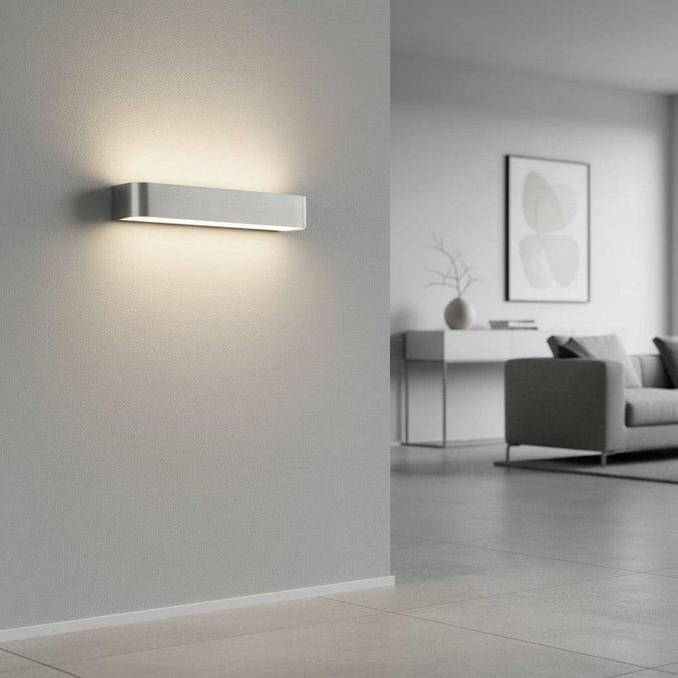 Silver up down indoor wall light on  neutral coloured wall in  modern home