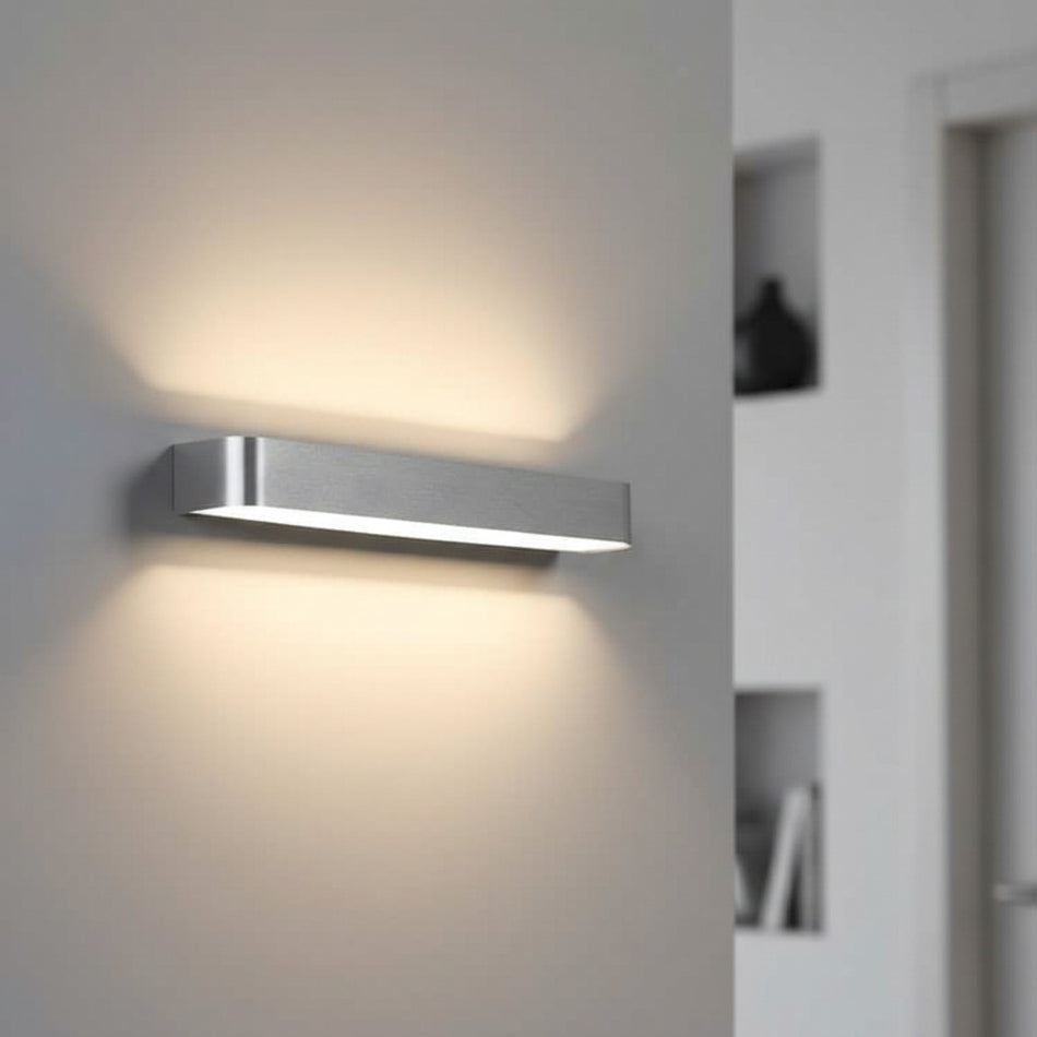 brushed silver up and down interior wall sconce mounted on the wall of a home 