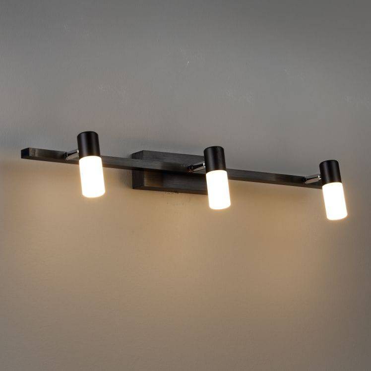 black vanity light over mirror mounted on a grey wall 