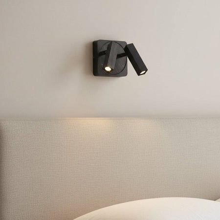 black over bed reading lamp mounted in a bedroom on the wall over a bed 