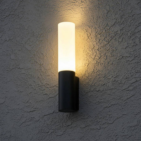 black lantern outdoor light mounted on an exterior textured wall 