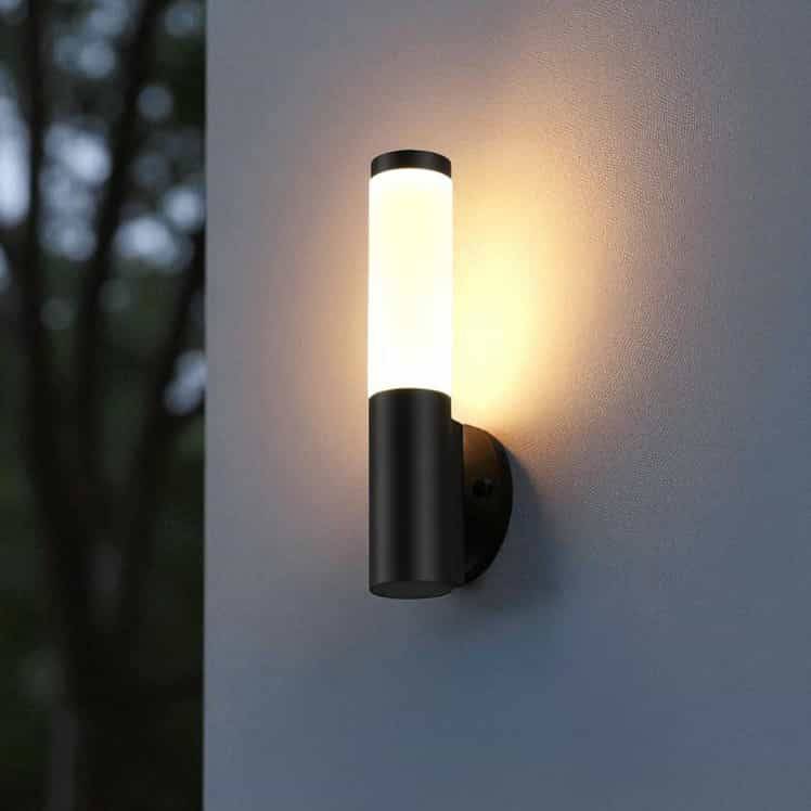 black outdoor wall lantern light installed on the exterior wall of a house on a white wall 