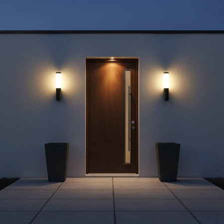 black outdoor wall lantern light mounted either side of a wooden front door 