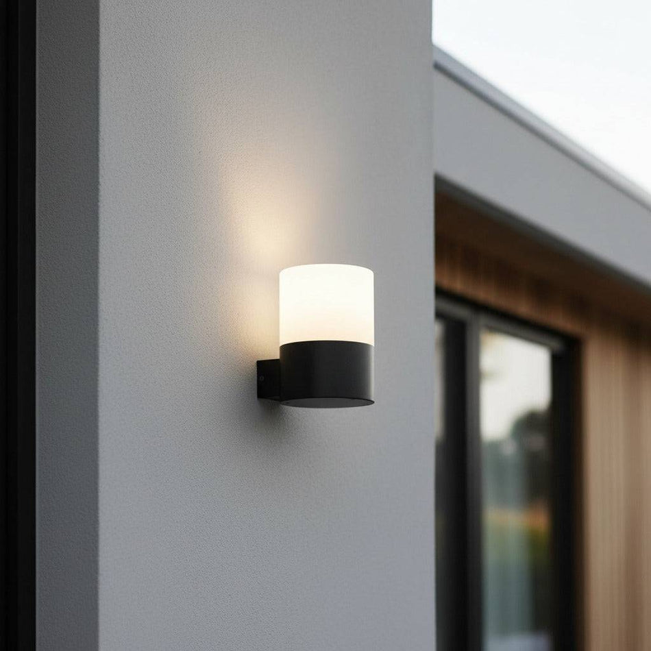 black outside wall mounted light fitted on the white wall of a modern house outdoors