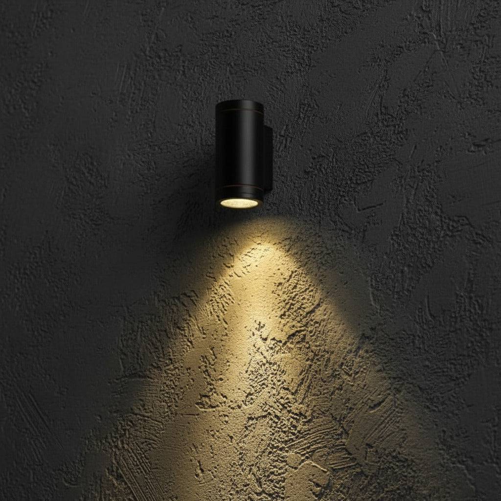 black outdoor LED wall downlight mounted on a textured exterior wall 