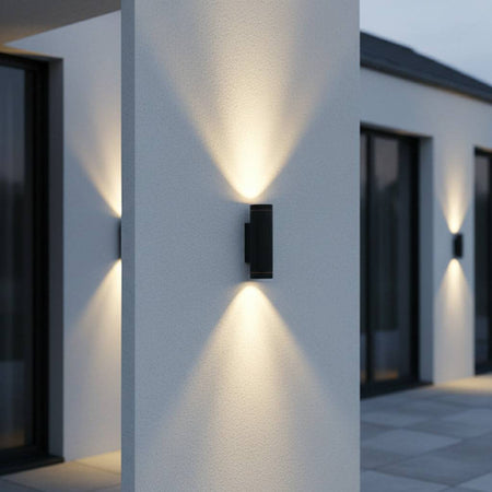 black outside up and down light mounted on a white column outside a modern house 