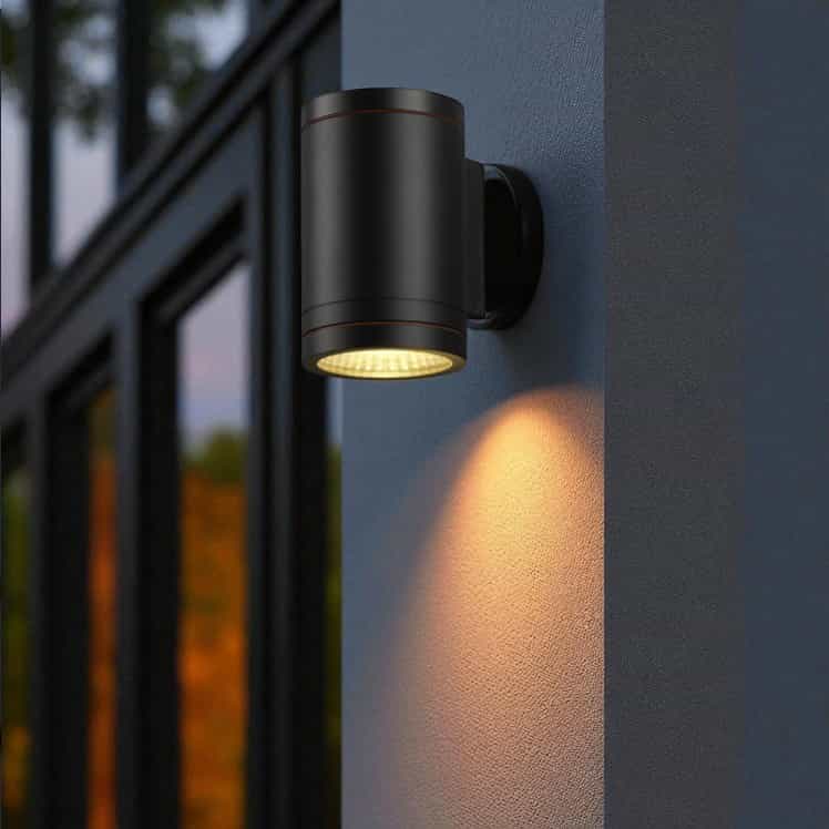 black outdoor wall downlight mounted on a white textured wall outside 