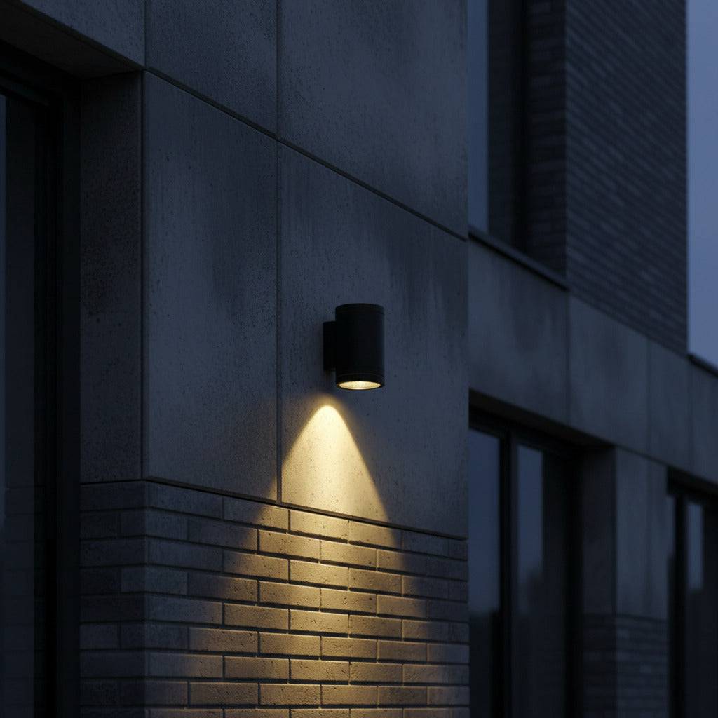 black outdoor wall downlight mounted on a concrete wall outside a building at night 
