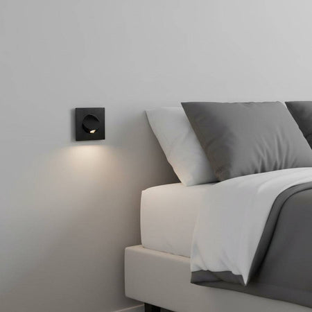 black recessed LED reading lamp for bed recessed into the wall next to a bed in a modern bedroom