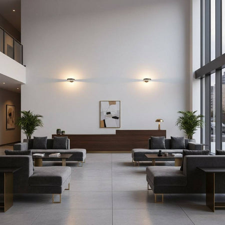 Black internal wall light in a hotel lounge two lights on the far end wall and sofas and tables in the picture