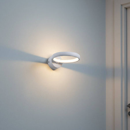 White indoor LED sconce light on a pale blue wall in a hallway
