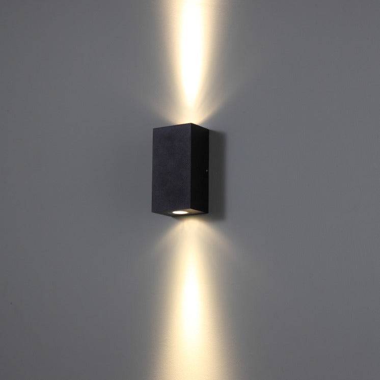 modern black bathroom sconce mounted on a white wall 