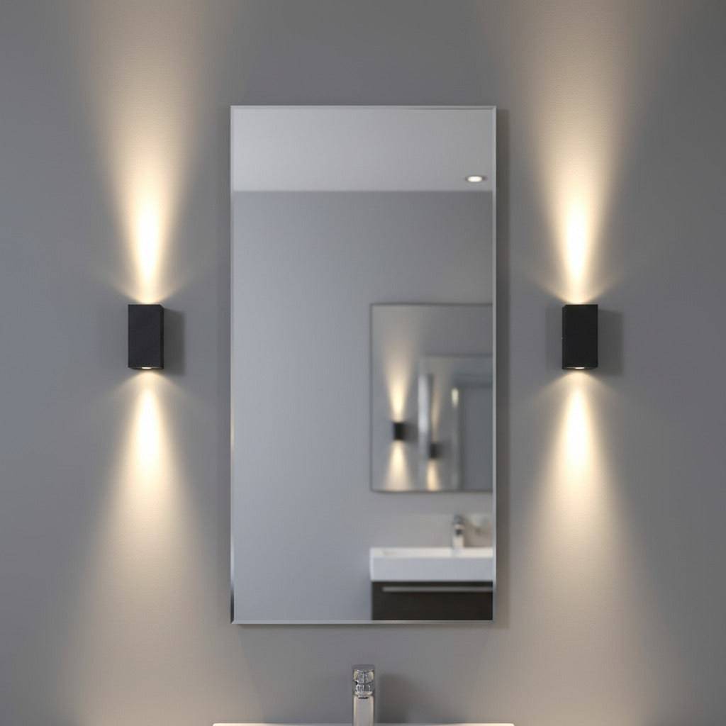 modern black bathroom sconce mounted either side of a mirror in a bathroom