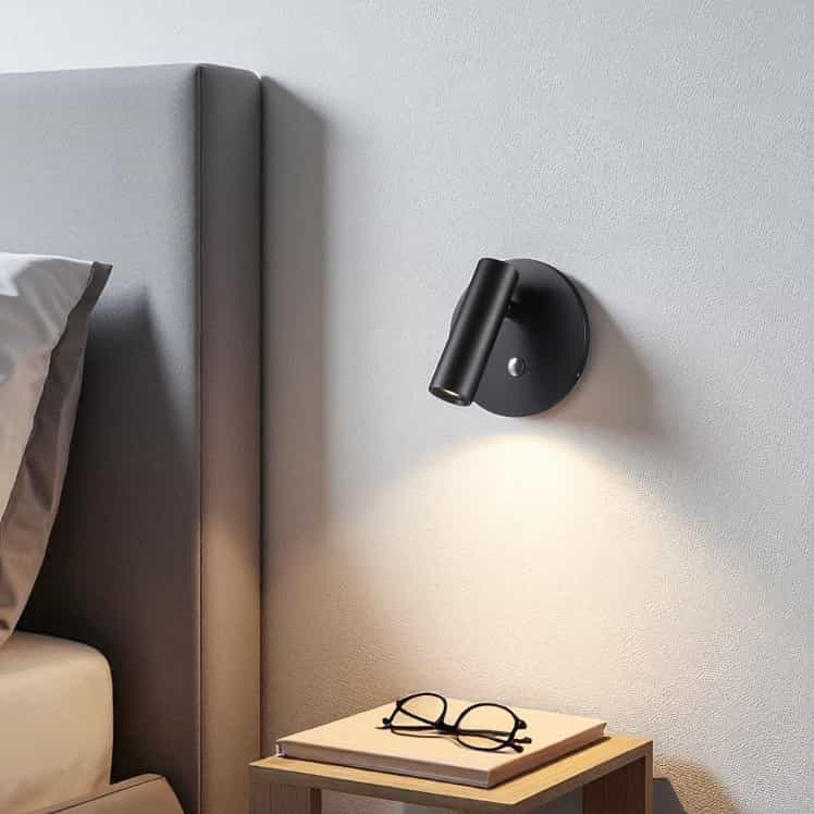 black recessed bed reading light mounted on the wall above a bedside table in a bedroom