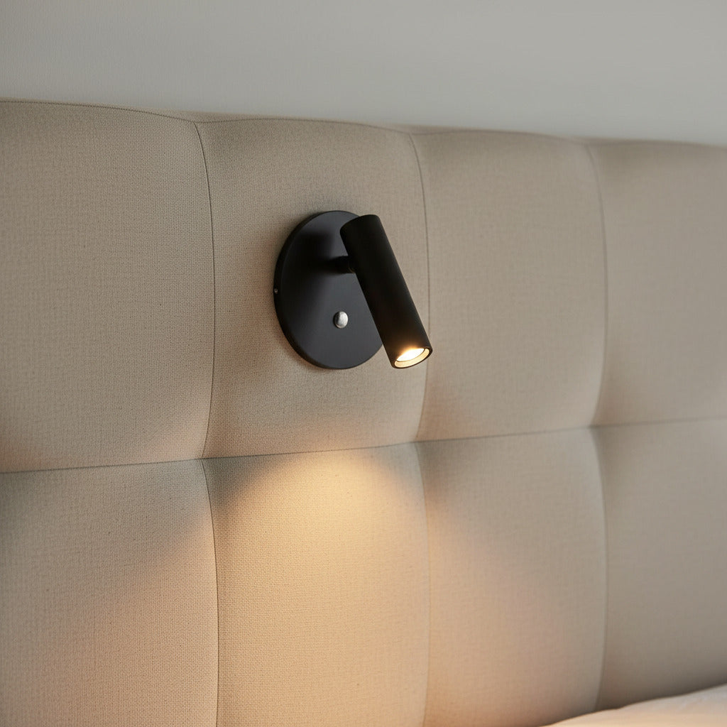 black recessed adjustable bed reading light mounted on a fabric headboard