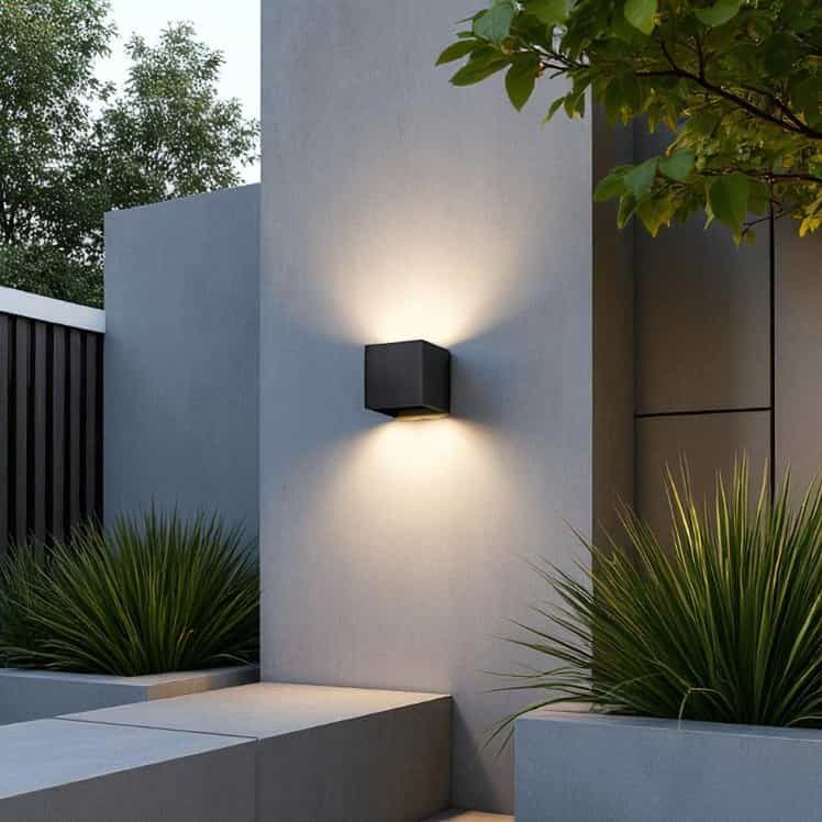 black up and down outdoor wall light mounted on the white exterior wall of a modern home 