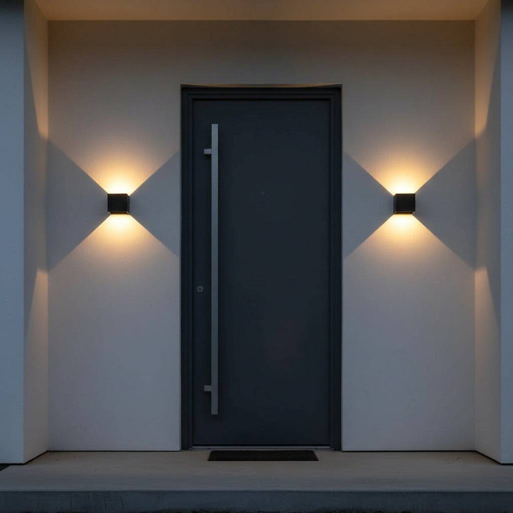 black up and down outdoor wall light mounted either side of the front door of a modern home 