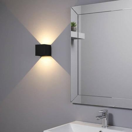 black wall bathroom lamp mounted next to a bathroom mirror