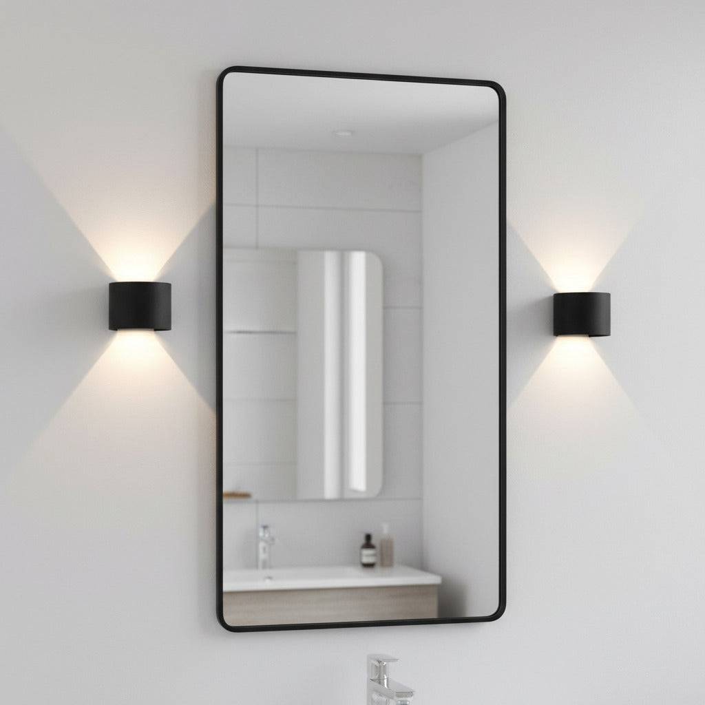 black bathroom wall sconce mounted either side of a bathroom mirror