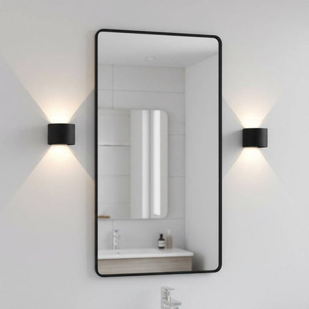 black bathroom wall sconce mounted either side of a bathroom mirror
