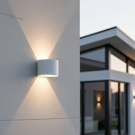 white outdoor up and down light mounted on a white concrete wall outside of a modern home 