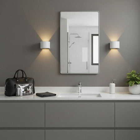 white wall mounted bathroom light fitted either side of a bathroom mirror 