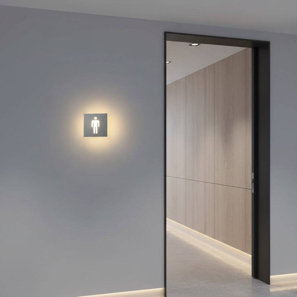 illuminated mens toilet sign on the wall next to a wc entrance