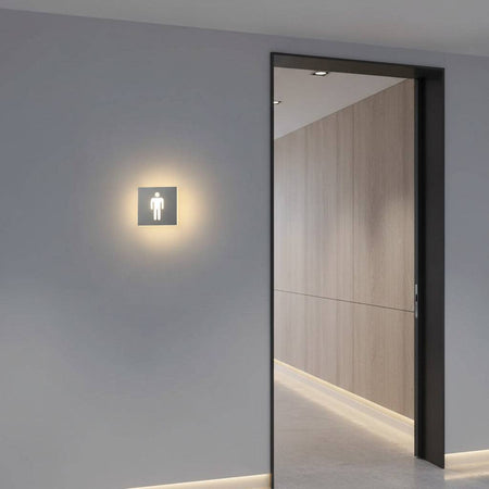 illuminated mens toilet sign on the wall next to a wc entrance