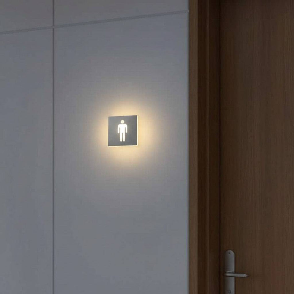 illuminated mens toilet sign mounted next to a door on the wall 