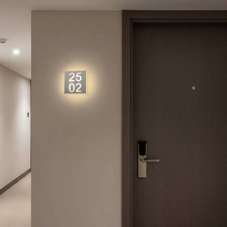 LED hotel room door number mounted outside a door in a hotel corridor