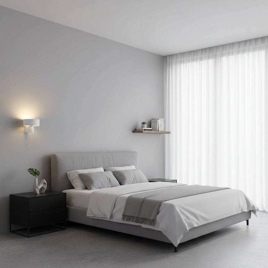 White wall mount interior light in a bedroom next to the bed on a neutral coloured wall