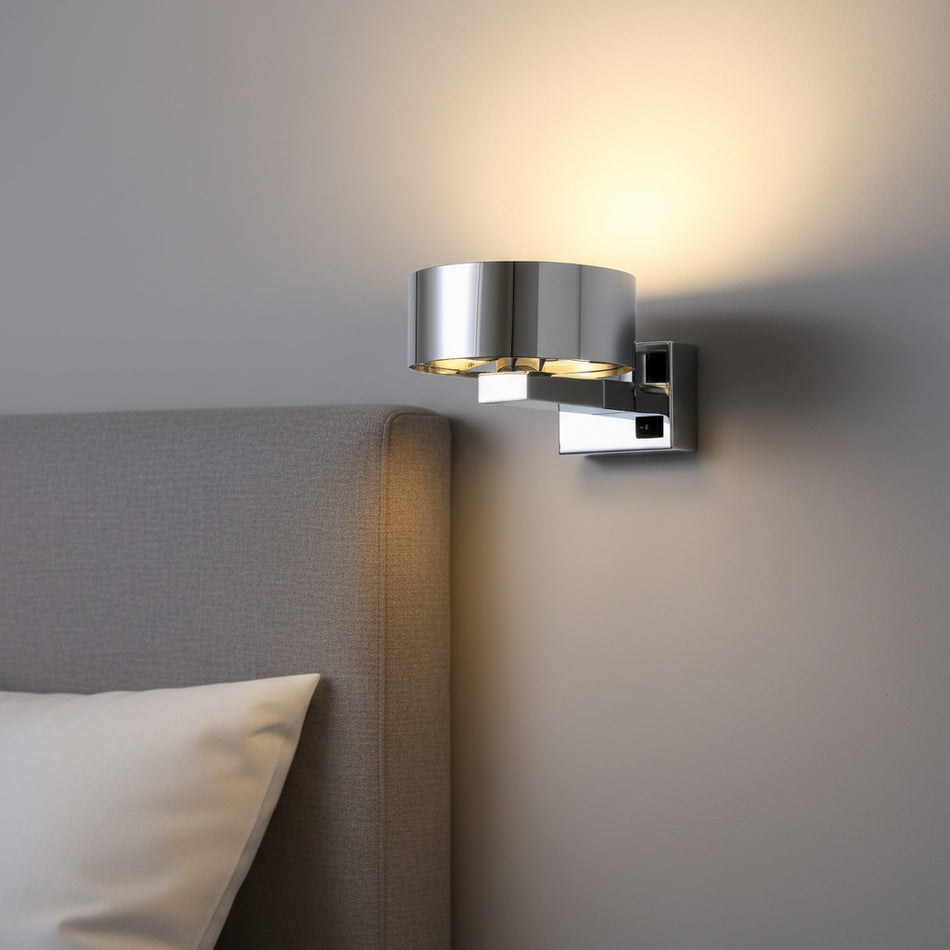 chrome bedside wall reading light mounted on the wall next to a bed