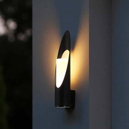 black outdoor LED wall lantern mounted on the outside of a modern home on a concrete wall 