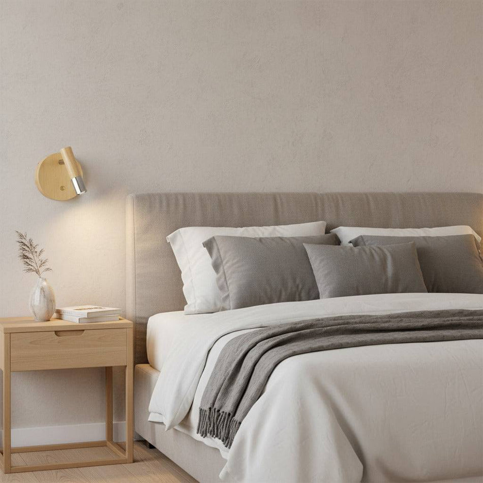 chrome adjustable wooden reading light mounted on the wall next to a bed in a modern bedroom