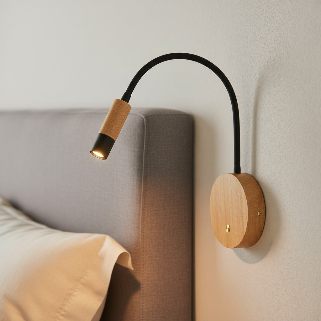 black flexible wooden reading lamp mounted next to a bed on the wall 