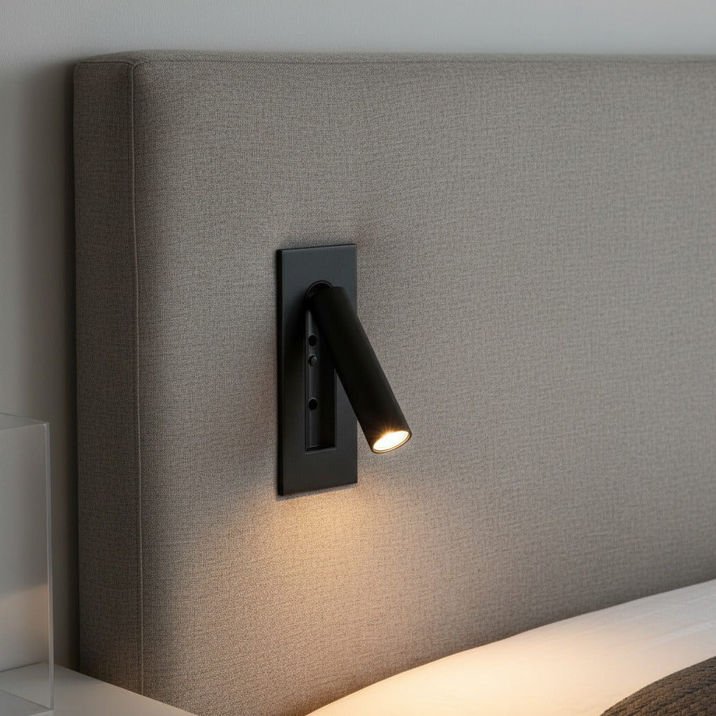 black recessed adjustable LED reading wall light mounted on a fabric bed headboard