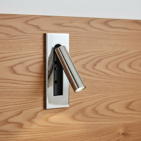 chrome recessed adjustable LED reading wall lamp mounted on a wooden bed headboard