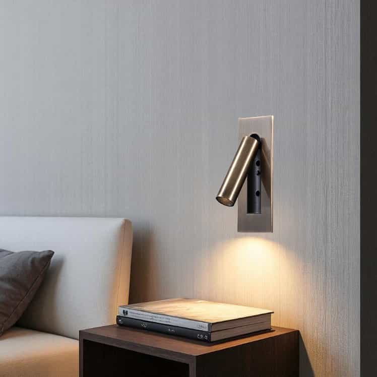 brushed copper recessed bedroom reading light mounted on the wall next to a bed over a bedside table 