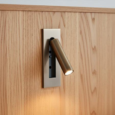 brushed copper recessed adjustable bedroom reading light mounted on a wooden headboard