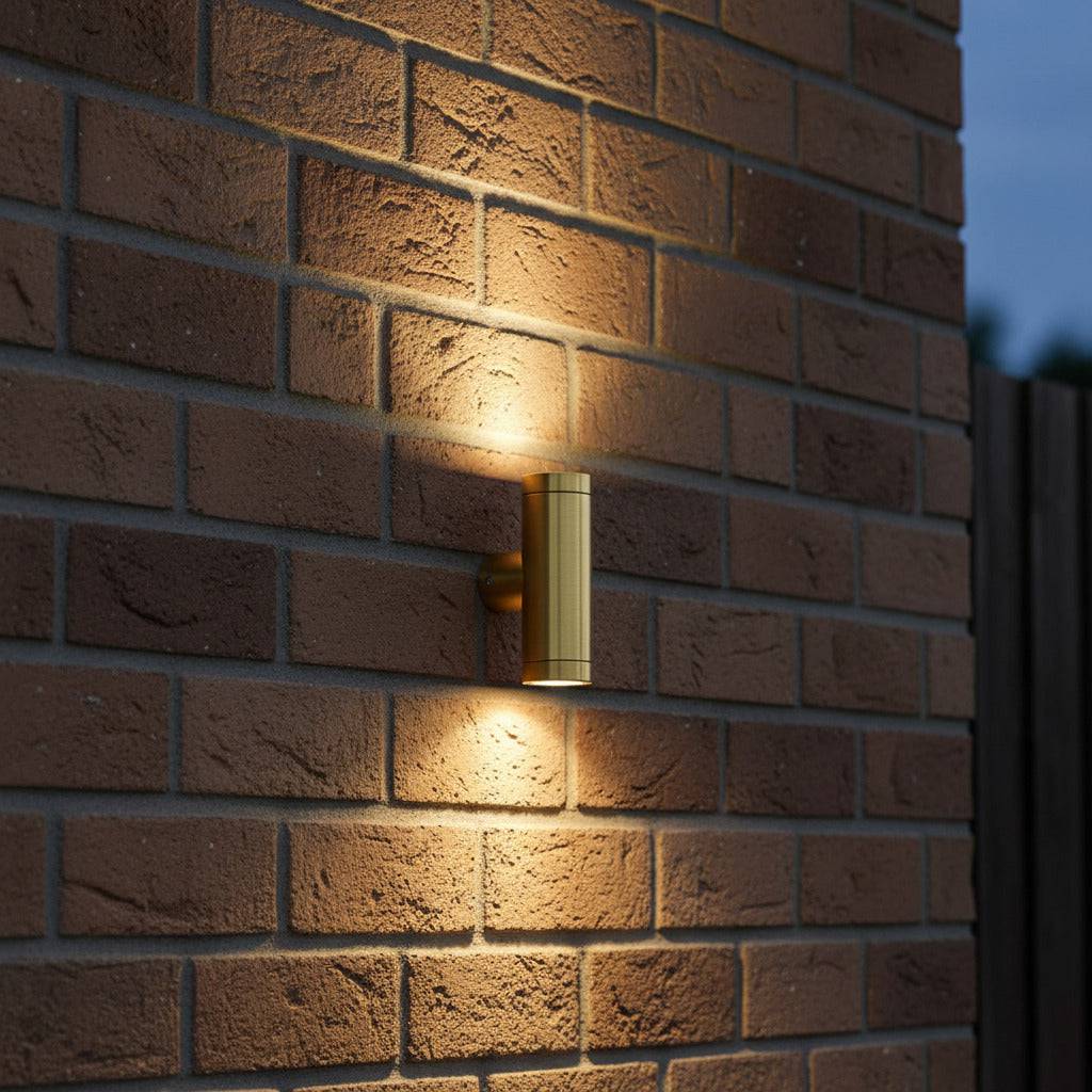 brass up down outdoor wall light mounted on a brick wall of a home 