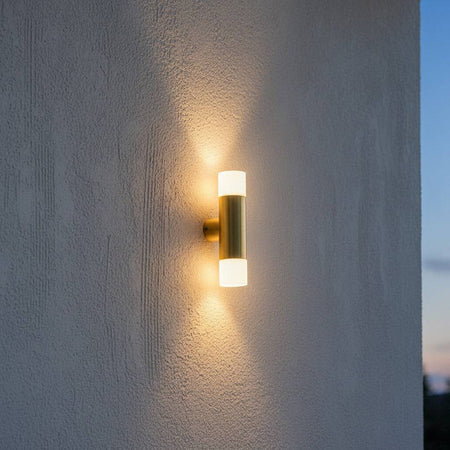 brass up and down exterior light mounted on a textured exterior wall 