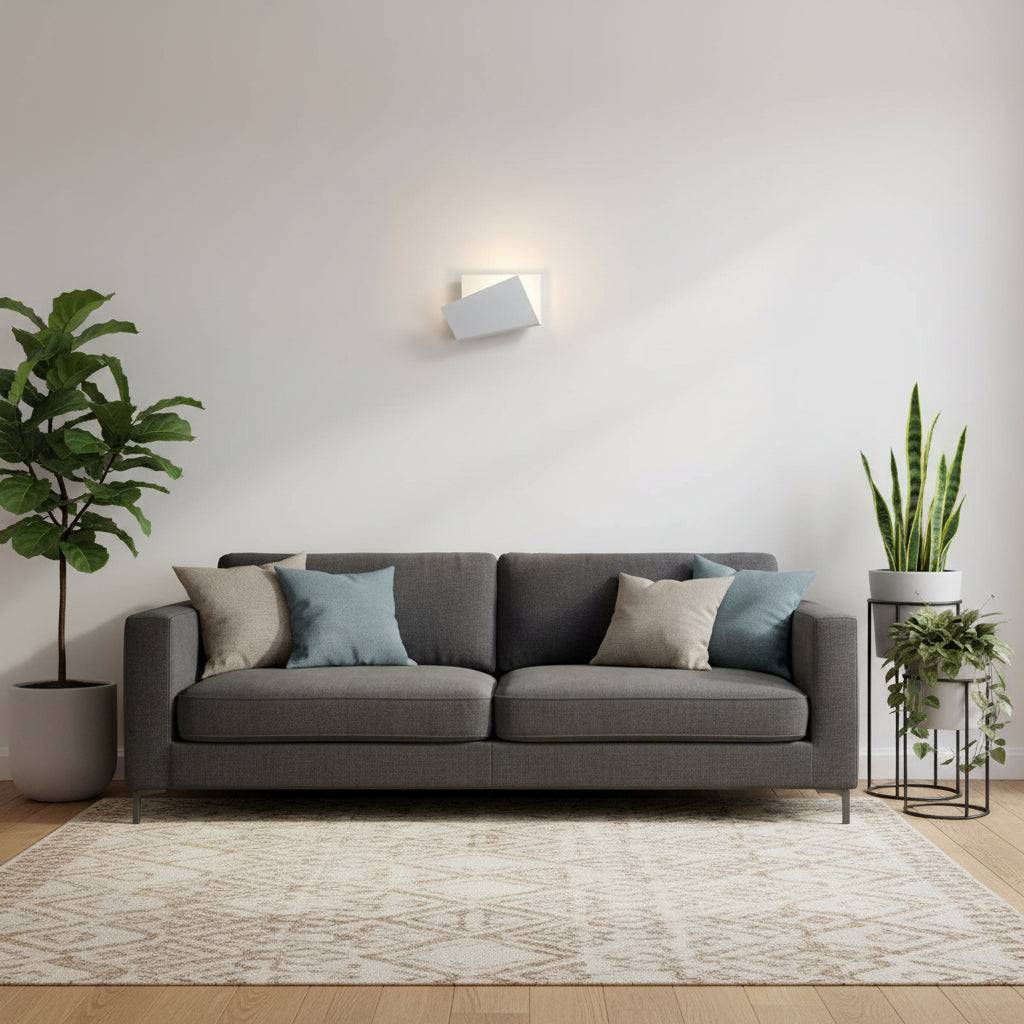 White indoor wall sconce on a white wall above a two seater sofa with plants either side