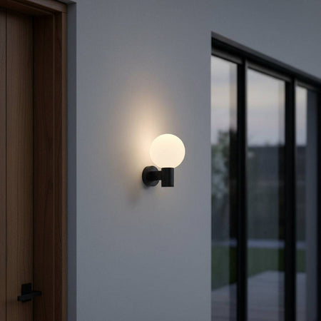 black globe outdoor wall light mounted on an exterior wall next to a wooden front door 
