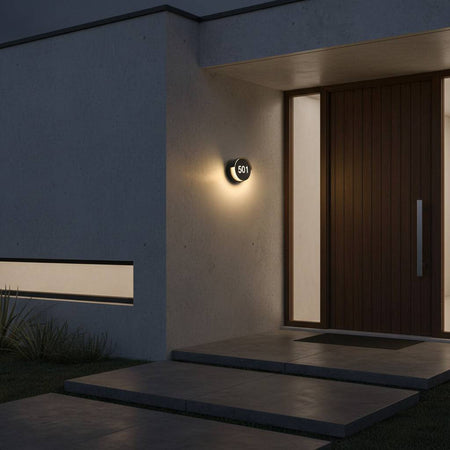 black illuminated door number mounted on the wall next a front door 