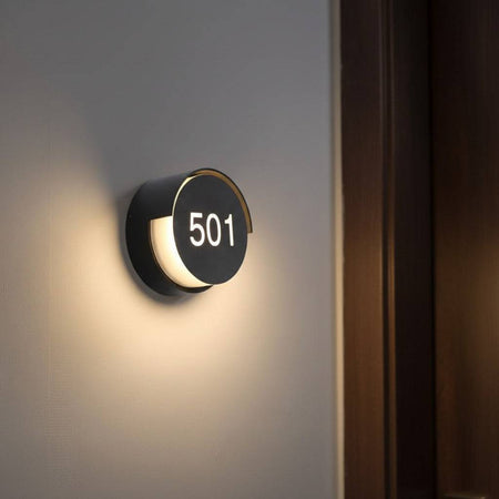 LED hotel room number sign mounted on the wall next to a hotel door