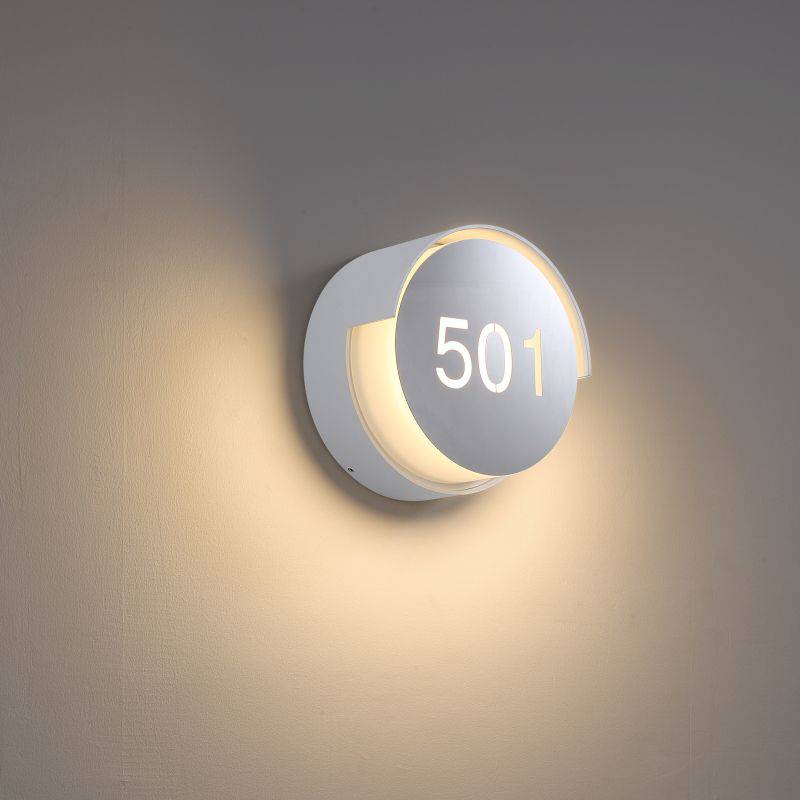Illuminated hotel room number sign mounted on a white wall 