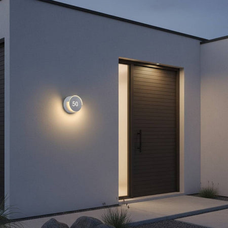 white LED house number sign mounted on the wall outside a modern home