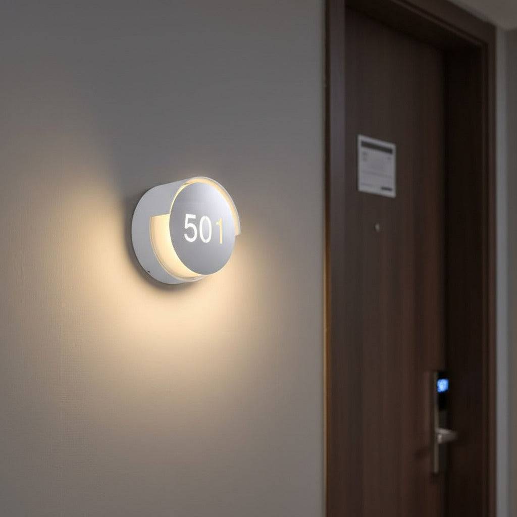 illuminated hotel room number sign mounted next to a hotel door 